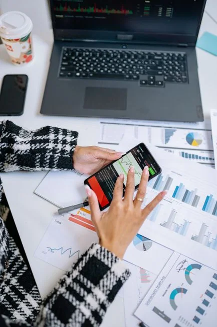 services-02 Vue rapprochée de l’écran d’un smartphone affichant la boîte de réception des e-mails, tenu dans la main d’un adulte.